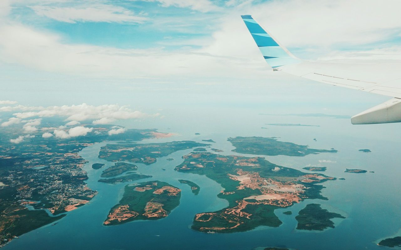 Vue d'îles et de lagons depuis le hublot de l'avion